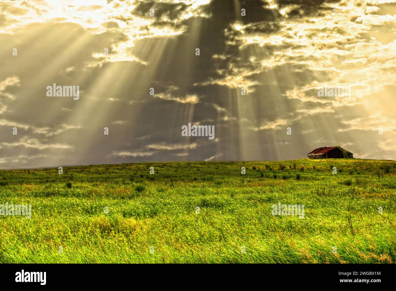 Sonnenstrahlen durch dunkle Wolken über ländliche Landschaft, Valmadonna, Alessandria, Piemont, Italien Stockfoto