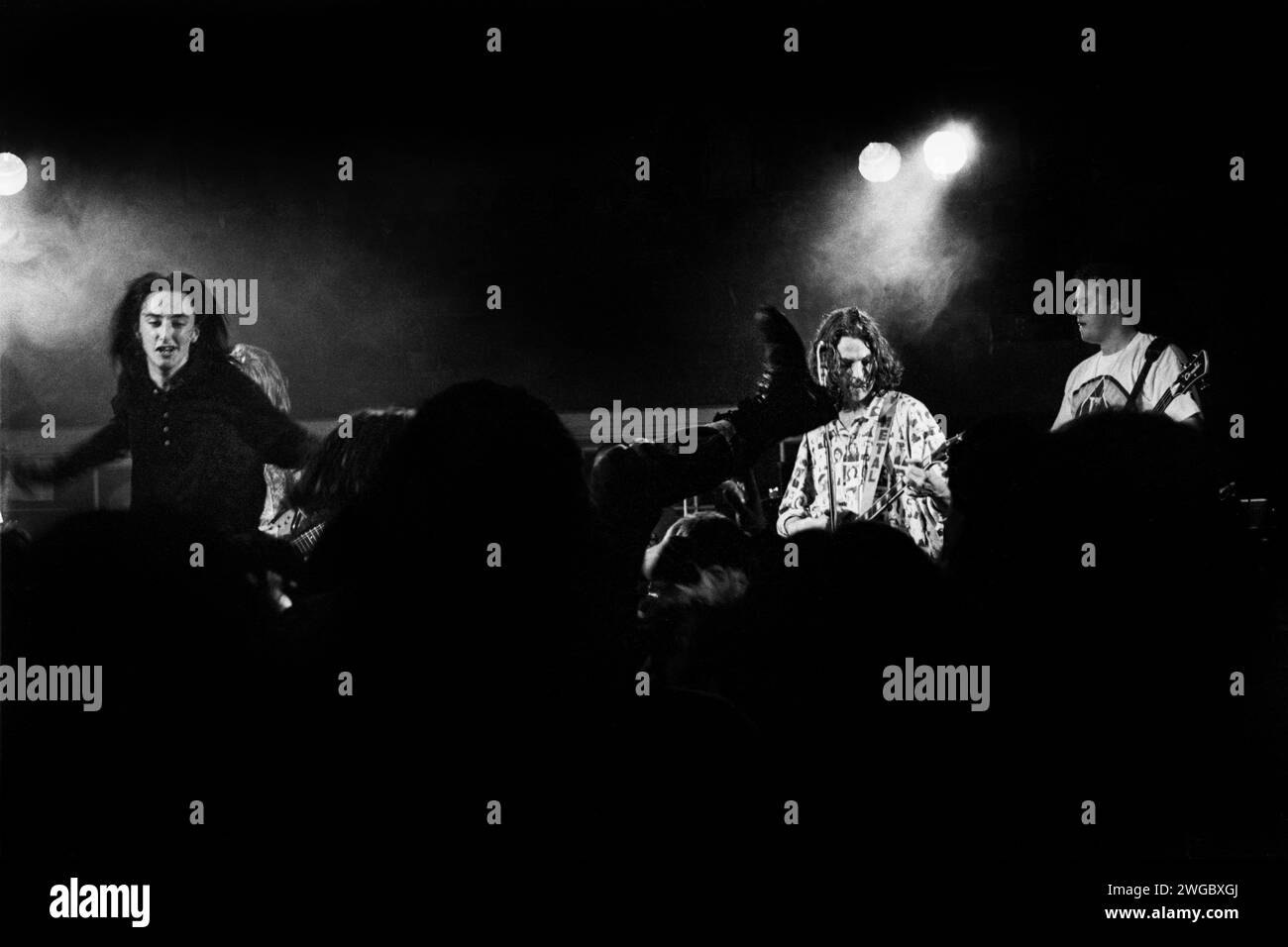 Stagedivers springen in Fornt of Paul Frederick (auch bekannt als Fred) von The Family Cat in Cardiff University Hanging Gardens am 20. Mai 1992 in Cardiff, Wales, Großbritannien. Foto: Rob Watkins. INFO: The Family Cat, eine britische Indie-Rock-Band aus den späten 80er und frühen 90er Jahren, lieferte eine unverwechselbare Mischung aus Alternative und Shoegaze. Ihr energiegeladener Sound, der in Alben wie Tell 'em We're Surfin' verkörpert wurde, trug zur lebendigen musikalischen Landschaft ihrer Ära bei. Stockfoto