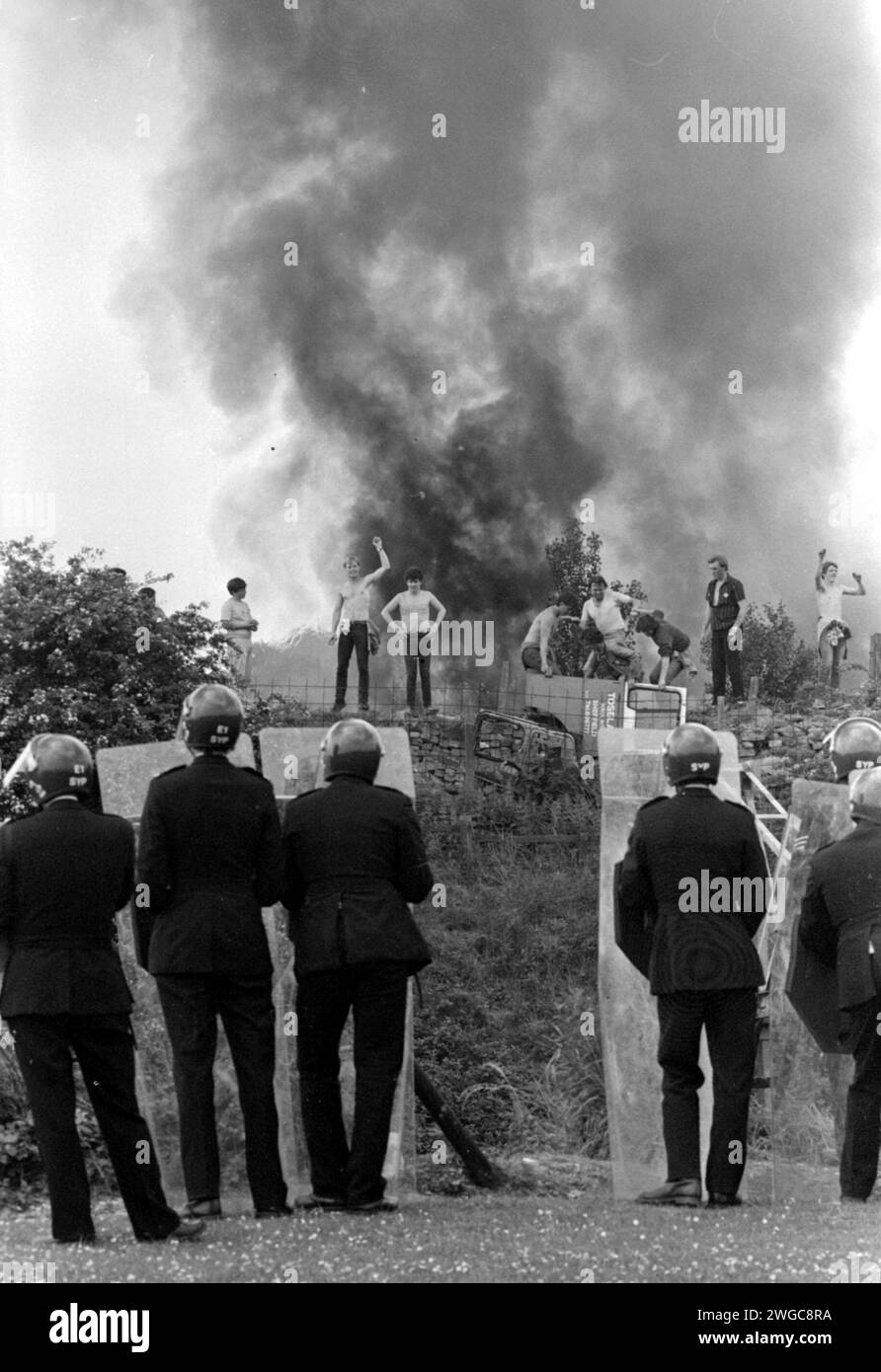 Aktenfoto vom 18. April 06/84, von der Polizei, die beobachtet, wie Streikposten vor dem Hintergrund brennender Autos in der Orgreave Coke Works, Yorkshire, gegenüberstehen. Die Forderung nach einer öffentlichen Untersuchung der Ereignisse an einem der gewalttätigsten Tage des jahrelangen Bergarbeiterstreiks wird verstärkt, nachdem im Fernsehen neue Aufnahmen von Zusammenstößen zwischen Polizei und Streikposten aufgezeichnet wurden. Die gewalttätige Konfrontation im Juni 1984 vor einem Kokerei in Orgreave, Yorkshire, führte dazu, dass viele Bergleute verletzt und verhaftet wurden, obwohl ihre Prozesse später zusammenbrachen. Ein dreiteiliger Channel 4-Dokumentarfilm über den Bergarbeiterstreik konzentrierte sich auf den so-Call Stockfoto