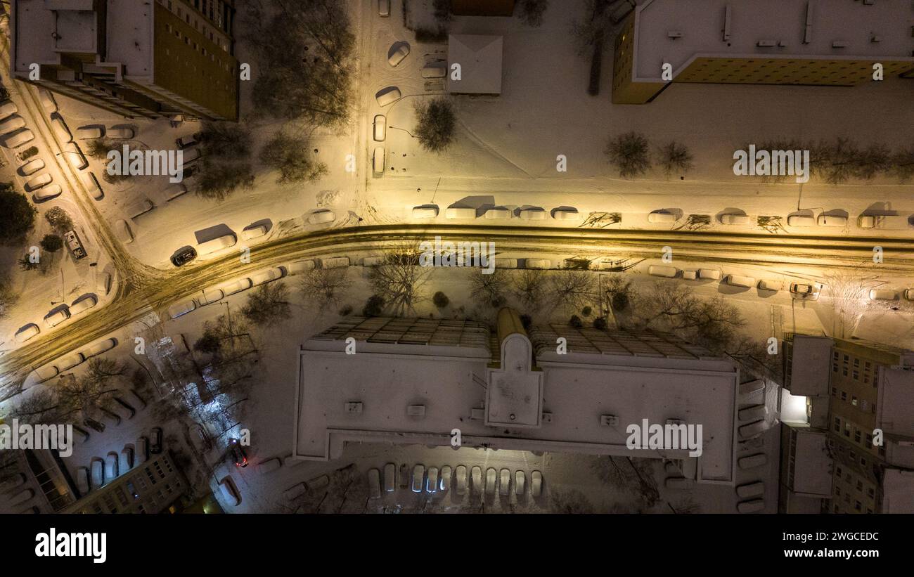 Drohnenfotografie der kleinen Stadtstraße am schneebedeckten Wintermorgen Stockfoto