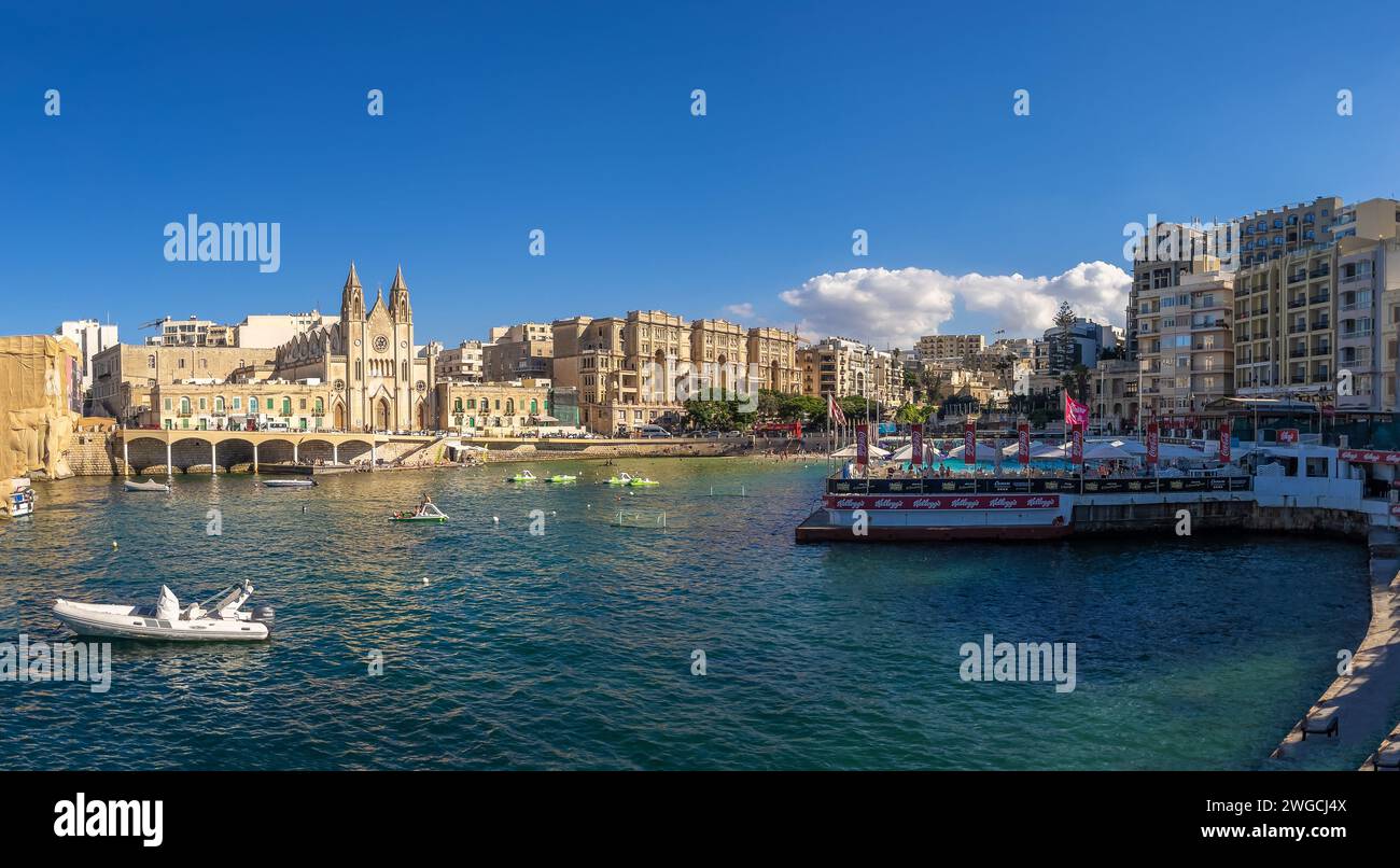 San Giljan (Saint Julian's), Malta - 25. August 2022: Balluta Bay mit der Pfarrkirche, den Balluta-Gebäuden und Neptunes WPSC. Stockfoto