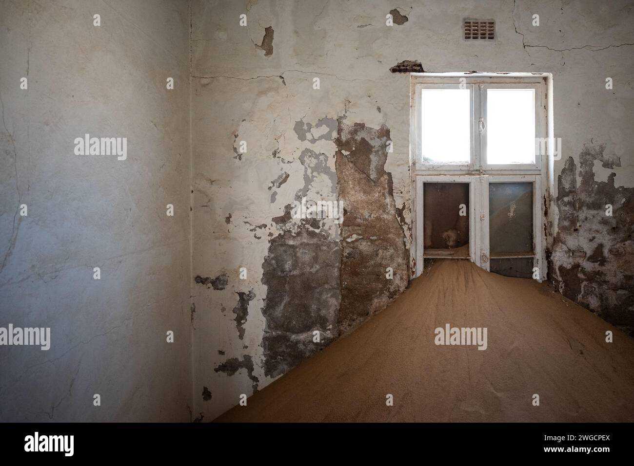 Ein verlassenes Zimmer mit sich verschlechternden Wänden und einem kleinen Fenster Stockfoto Ein verlassenes Zimmer mit sich verschlechternden Wänden und einem kleinen Fenster Stockfoto