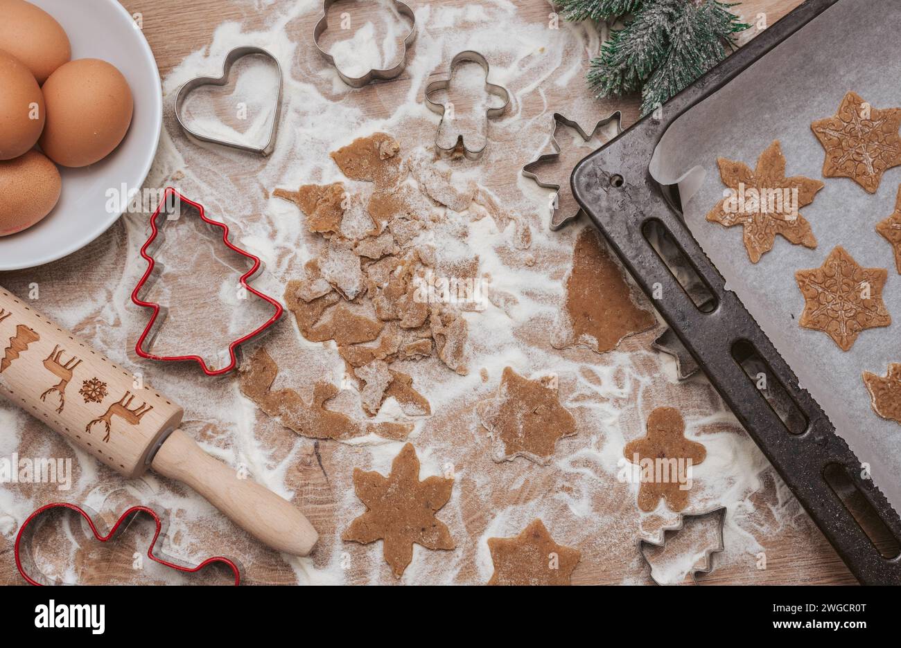 Direkt über dem Blick auf Keksteig, Küchenutensilien und Keksschneider für weihnachtskekse Stockfoto