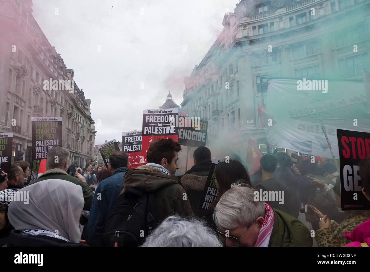 London, Großbritannien - 3. Februar 2024 - Demonstranten mit Rauchfackeln am Oxford Circus während eines Protestes, der zu einem Waffenstillstand in Gaza aufrief. März organisiert von der palästinensischen Solidaritätskampagne. Stockfoto