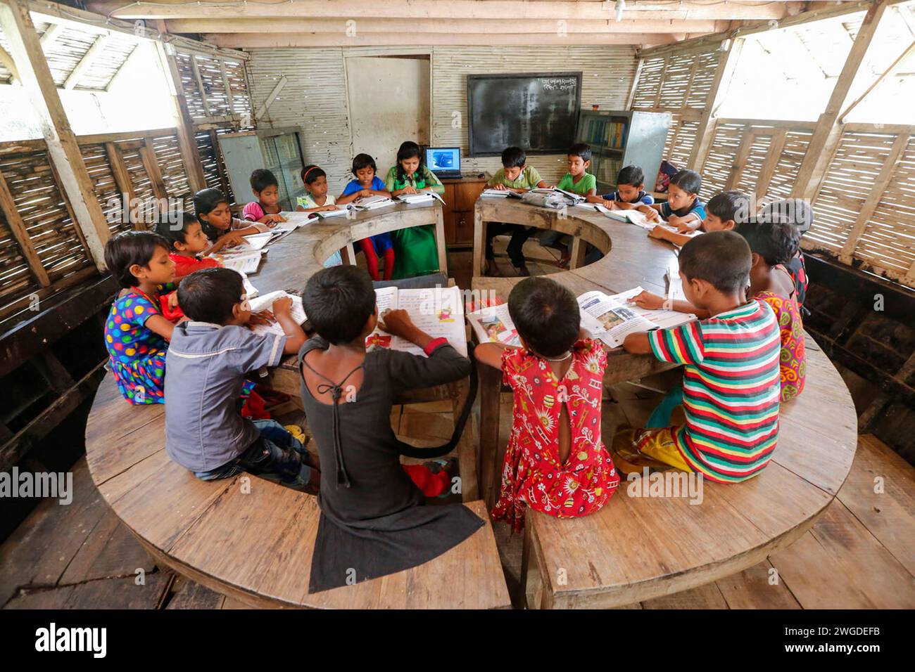 Dorfschüler besuchen eine Klasse an der Chalk Lanka Boat School. 2007 kam es zweimal zu Überschwemmungen, 332 Schulen wurden zerstört und 4.893 Schulen wurden beschädigt. Shidhulai betreibt eine Flotte schwimmender Schulen, Bibliotheken, Gesundheitskliniken, Solaranlagen und schwimmende Schulungszentren mit drahtlosem Internetzugang, die fast 97.000 Familien in wassergefährdeten Regionen bedienen. Boote selbst sind mit Solarpaneelen ausgestattet, die Computer, Leuchten und medizinische Geräte versorgen. Singra, Natore, Bangladesch. Stockfoto