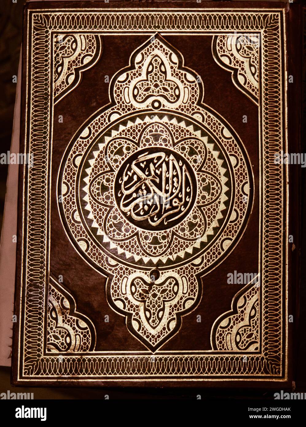 Geprägtes Gold auf braunem Lederbezug eines Korans oder Korans in einer Moschee Stockfoto