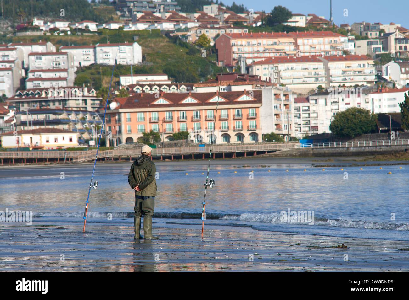 BAIONA, PONTEVEDRA, SPANIEN; Juli 2021: UN pescador en la Playa de la ladeira en baiona esperando para ver si pican los peces Stockfoto