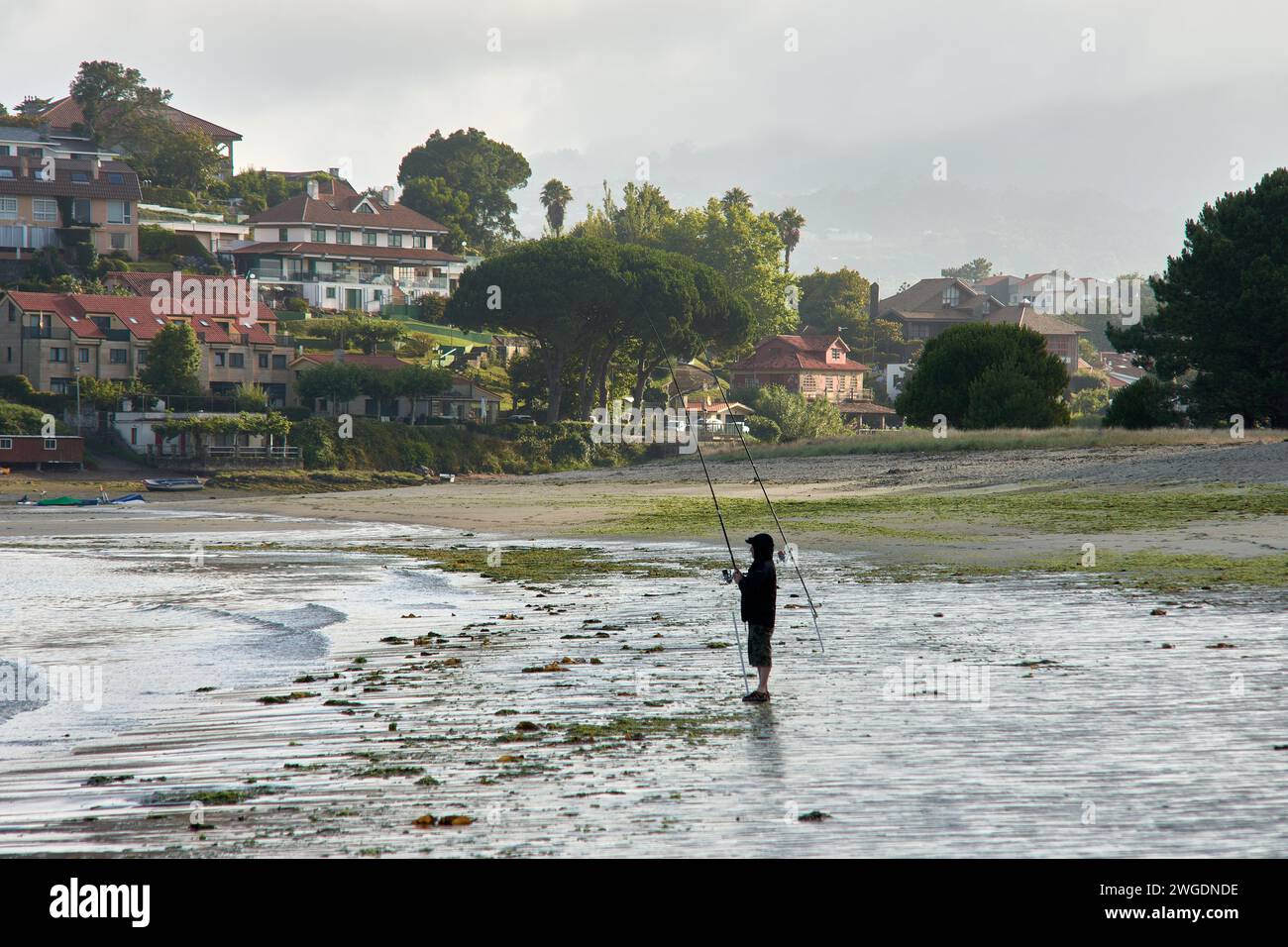 BAIONA, PONTEVEDRA, SPANIEN; Juli 2021: UN pescador en la Playa de la ladeira en baiona esperando para ver si pican los peces Stockfoto