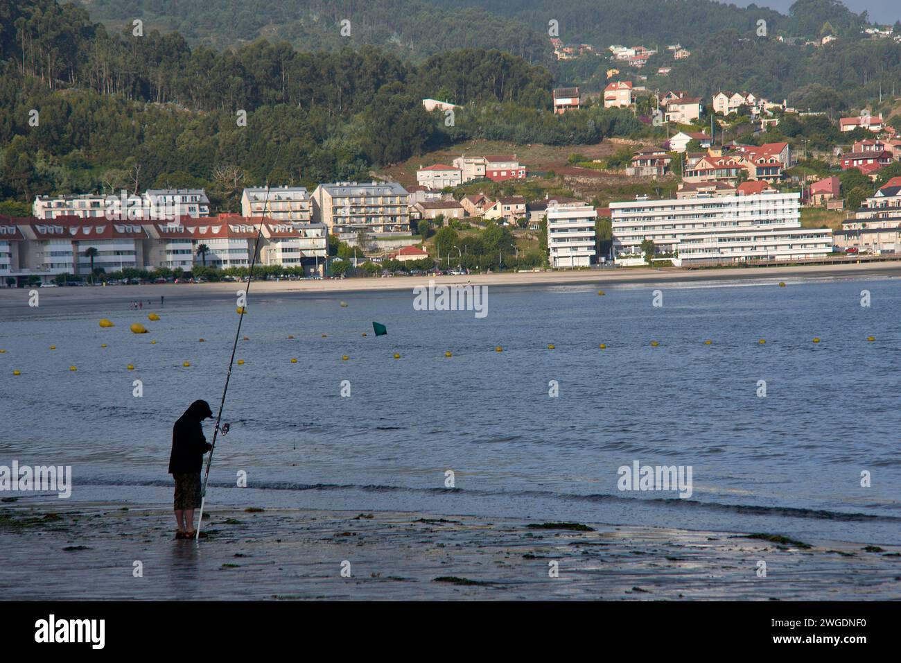 BAIONA, PONTEVEDRA, SPANIEN; Juli 2021: UN pescador en la Playa de la ladeira en baiona esperando para ver si pican los peces Stockfoto