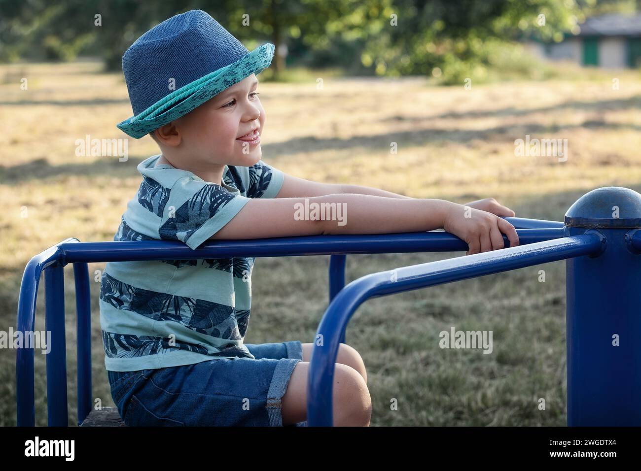 Kleiner Junge, der Spaß beim Karussell im Park hat. Stockfoto
