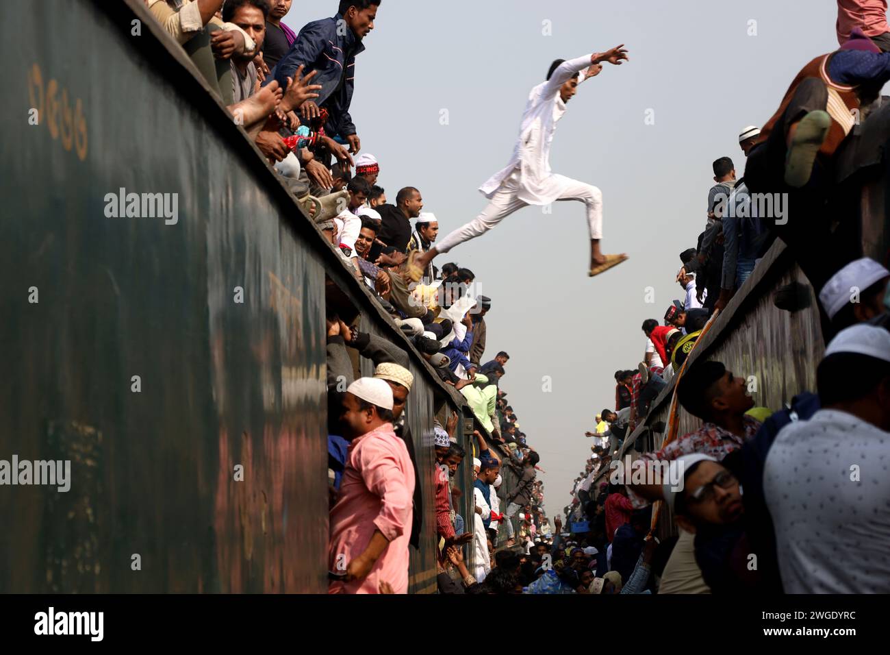 Tongi, Gazipur, Bangladesch. Februar 2024. Ein Anhänger von Bishwa Ijtema springt von einem Zug zum anderen, um am Bahnhof Tongi in Gazipur den richtigen Zug zu erreichen. Bishwa Ijtema (Welt Ijtema) ist die zweitgrößte muslimische Versammlung der Welt. Jedes Jahr nehmen Millionen Menschen aus dem ganzen Land und dem Ausland an Ijtema Teil. (Kreditbild: © Syed Mahabubul Kader/ZUMA Press Wire) NUR REDAKTIONELLE VERWENDUNG! Nicht für kommerzielle ZWECKE! Stockfoto