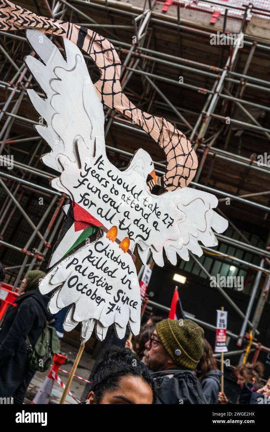 London, Großbritannien. Februar 2024. Ein Banner in Form einer Friedenstaube und zur Unterstützung von Kindern, die während des israelisch-Gaza-Krieges leiden, gehalten von Friedensaktivisten und Demonstranten während des Pro-Palästina-marsches durch die Oxford Street in Soho, Freie Palästina-Bewegung , London, Großbritannien Stockfoto