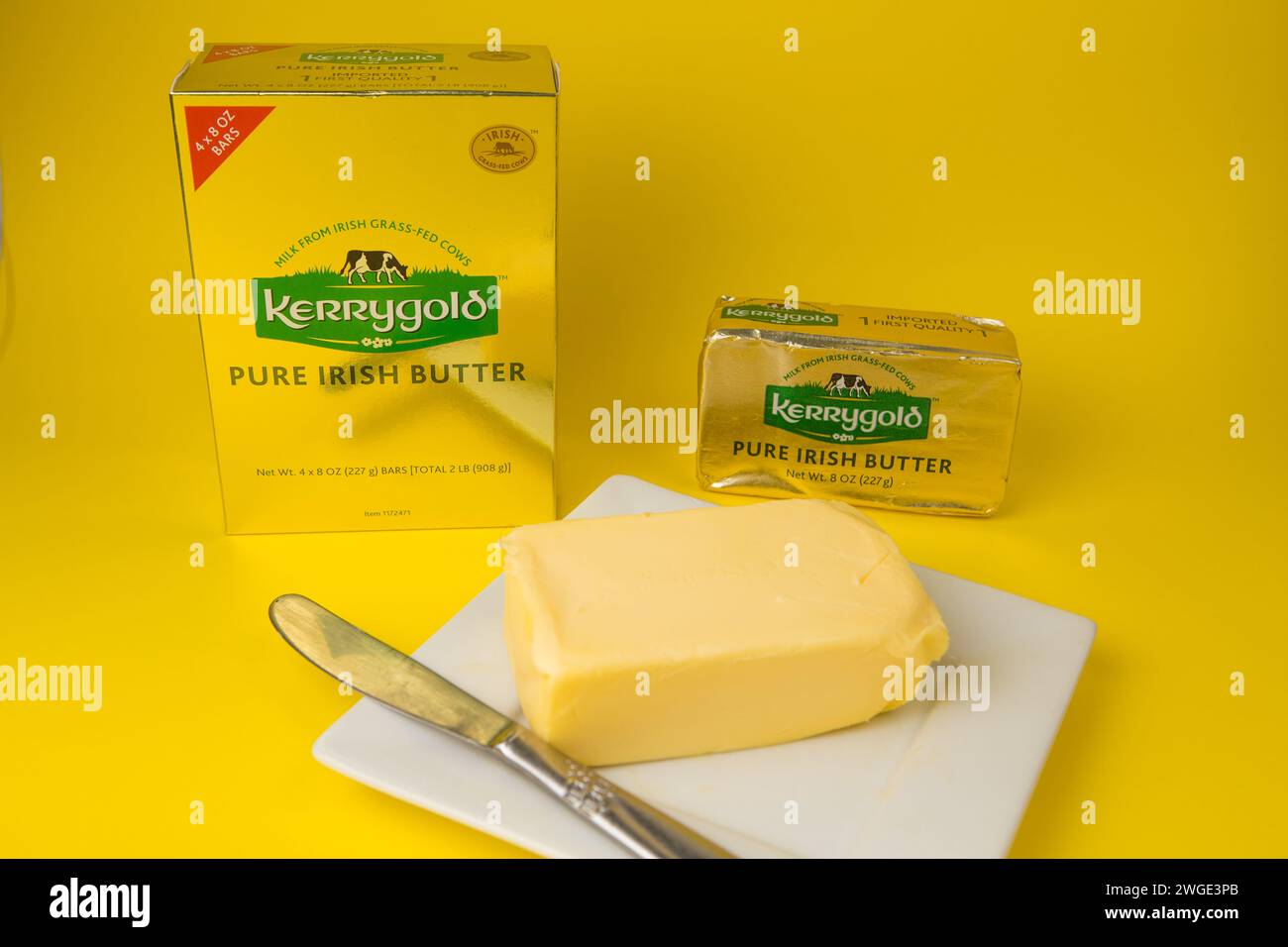 Packungen mit irischer Kerrygold-Butter, die in die USA eingeführt wurden, auf gelbem Hintergrund Stockfoto