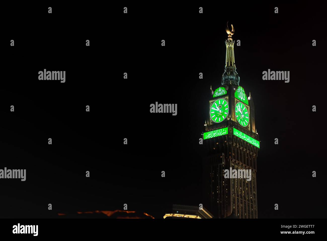 Mekka, Saudi-Arabien - 07. März 2023: Grüner beleuchteter Wachturm des Abraj Al Bait-Gebäudes in Mekka vor schwarzem Nachthimmel. Höhe 601 m es sind vier Stockfoto