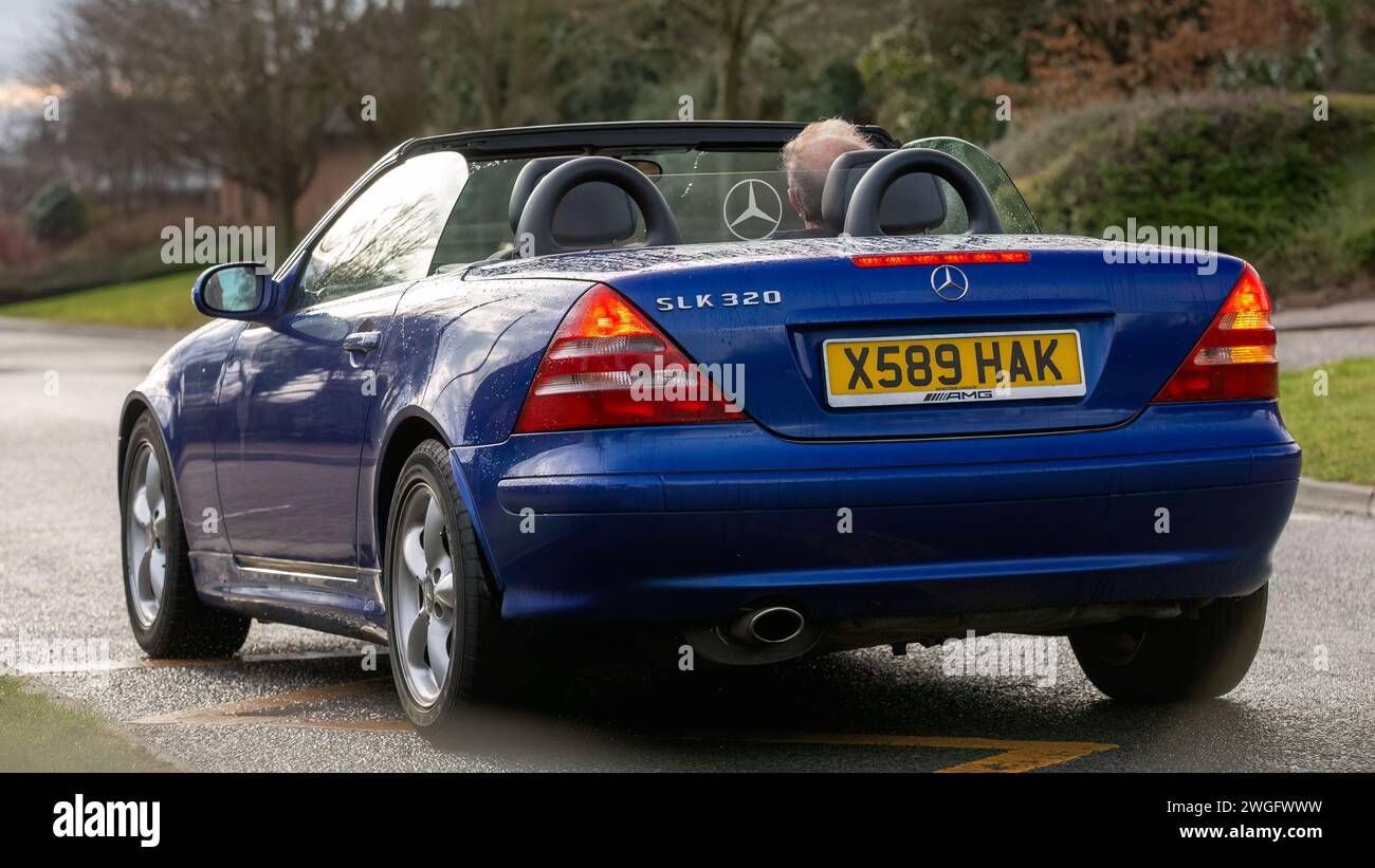 Milton Keynes, UK-4. Februar 2024: 2000 blauer Mercedes Benz SLK Oldtimer mit offenem Oberdeck, der auf einer englischen Straße fährt. Stockfoto