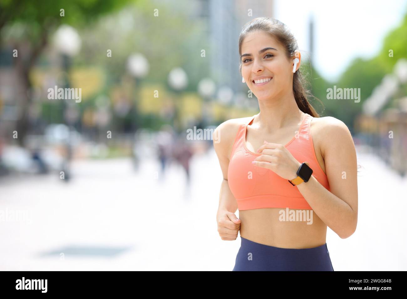 Fröhlicher Läufer, der Musik über Kopfhörer auf der Straße hört Stockfoto