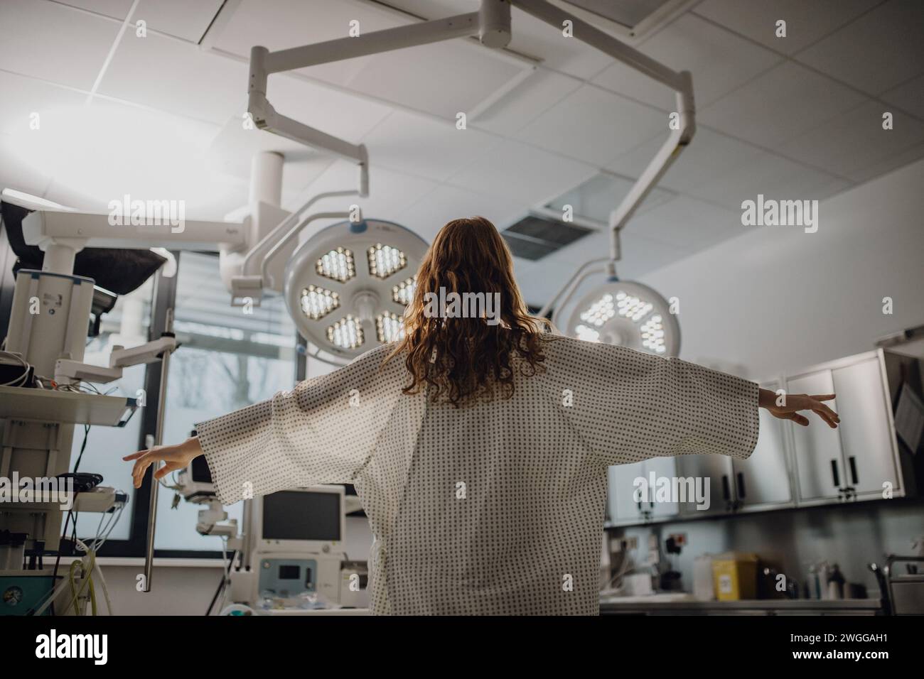 Rückansicht des Patienten im Krankenhausmantel in der Notaufnahme. Sieht aus wie ein Engel. Stockfoto