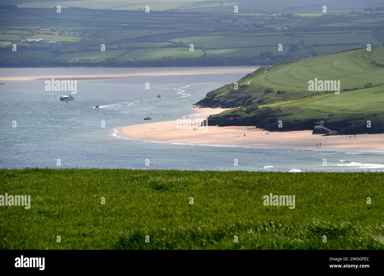 Menschen, die am Strand von Harbour Cove in Padstow Bay vom Stepper Point auf dem South West Coastal Path in Cornwall, England, wandern. Stockfoto