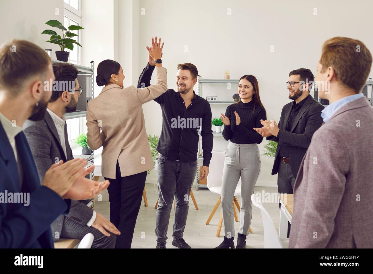 People gh 5 gratuliert einander zu den geschäftlichen Errungenschaften und ausgezeichneten Ergebnissen bei der Arbeit. Stockfoto