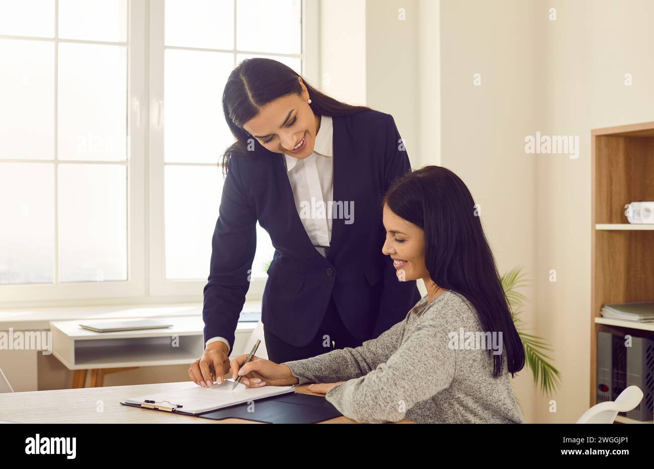 Geschäftsfrau unterzeichnet Vertrag bei Geschäftstreffen im Büro Stockfoto
