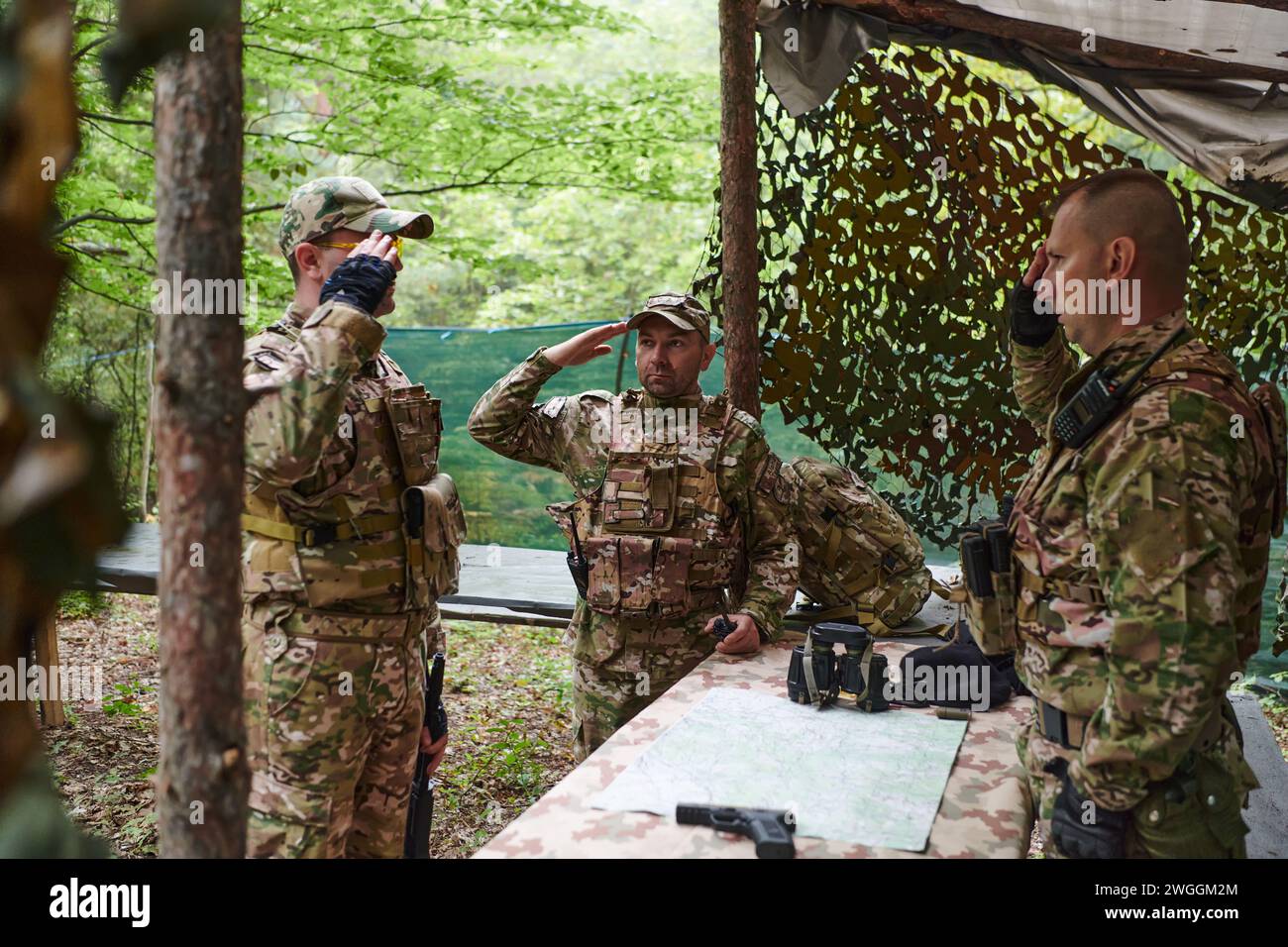 Eine gut ausgebildete Militäreinheit organisiert eine taktische Mission, während sie während einer Besprechung eine Militärkarte studiert Stockfoto