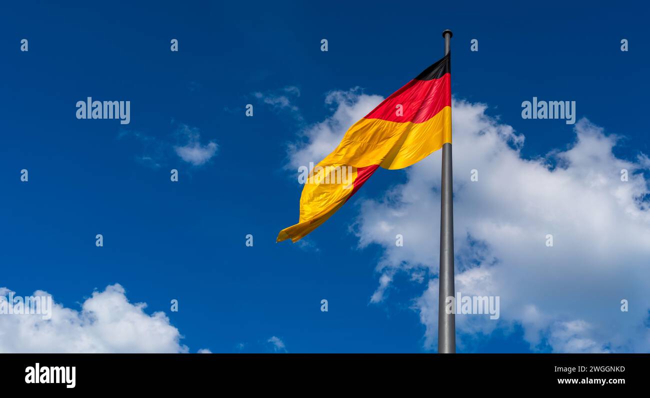 Flagge der Demokratischen Republik Deutschland gegen den Sommerhimmel Stockfoto