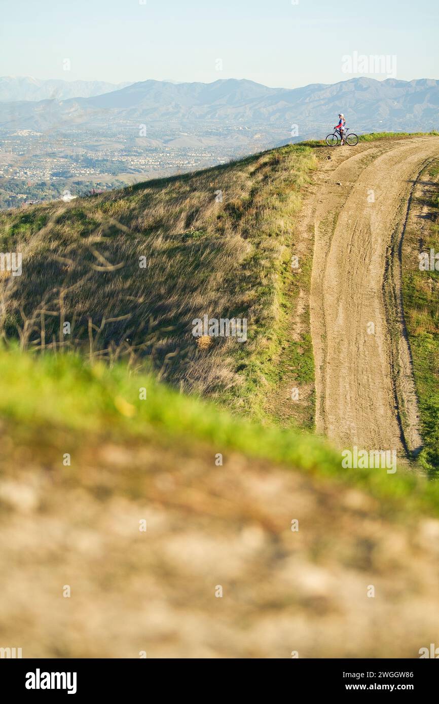 Eine aktive Frau Mitte 20 fährt bei Sonnenaufgang in Südkalifornien mit dem Mountainbike. Stockfoto