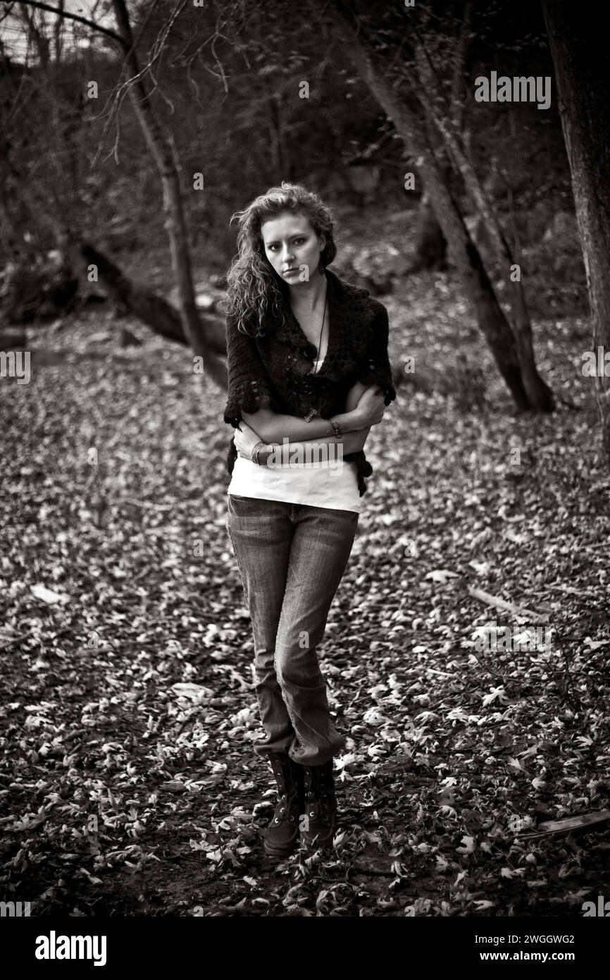 Ein Porträt einer jungen Frau mit lockigem Haar, die im Herbst einen Pullover trägt. Stockfoto