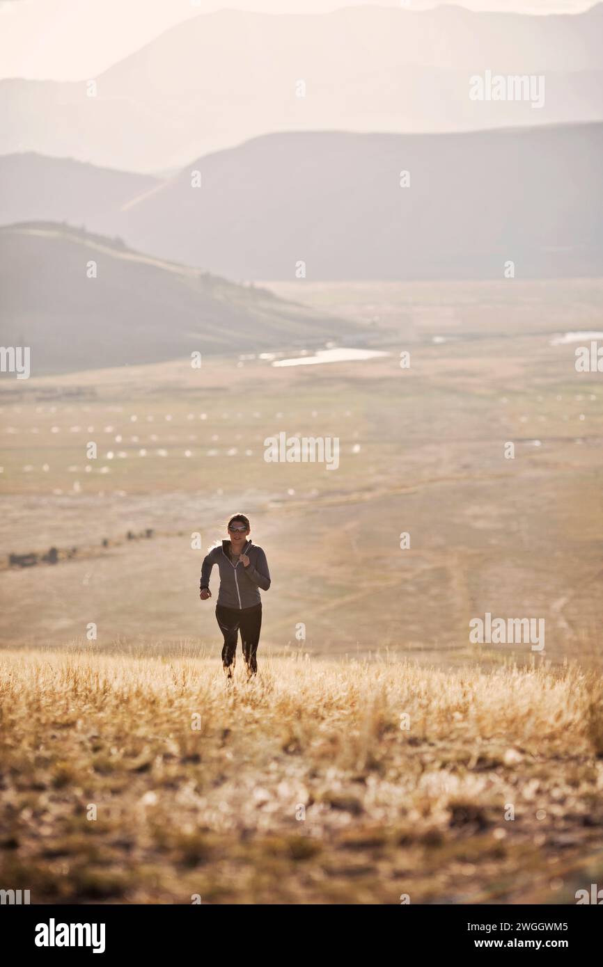 Eine Läuferin läuft einen Hügel in der Nähe von Jackson, Wyoming. Stockfoto