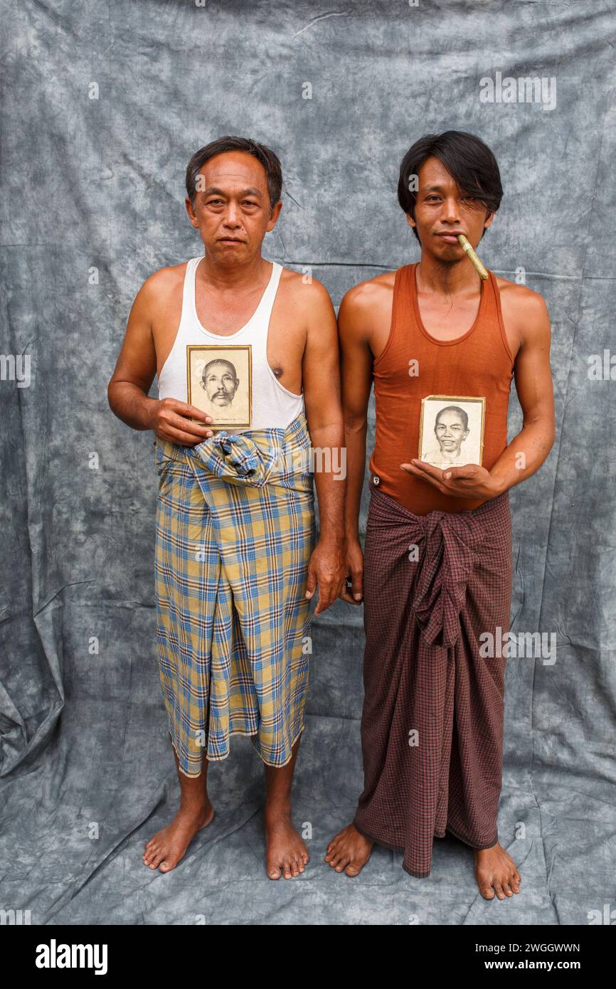 Schlepphandwerker am Inle Lake, Myanmar, halten Porträts von Verwandten, die eine lokale Bootsbauwerkstatt betrieben haben Stockfoto