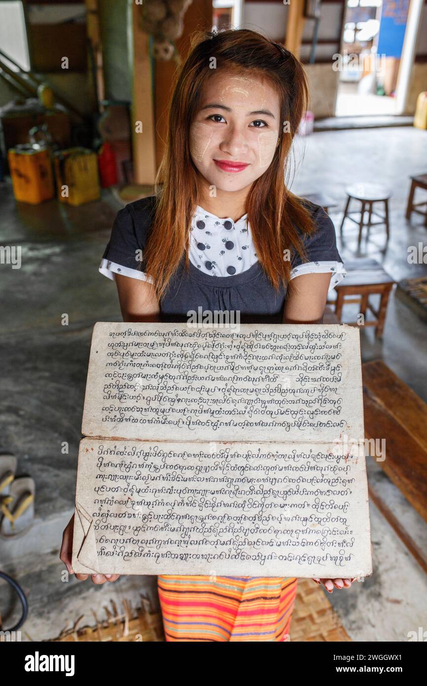Die junge Frau hält einen antiken buddhistischen Text in der Nähe des Inle Lake, Myanmar Stockfoto