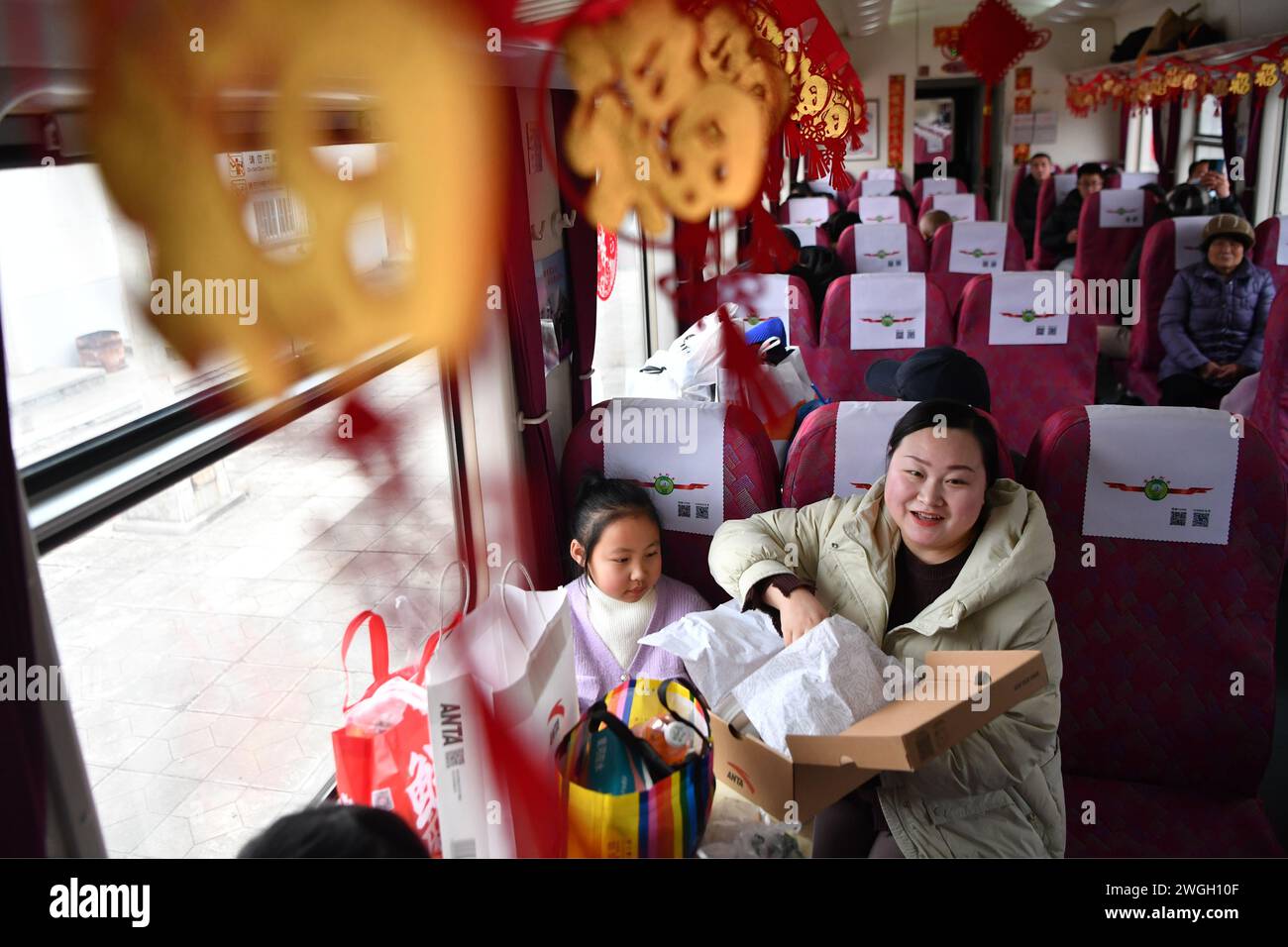 Longxi. Februar 2024. Dieses am 4. Februar 2024 aufgenommene Foto zeigt Passagiere auf dem Heimweg nach dem Einkaufen im Zug Nr. 7503 in der nordwestlichen chinesischen Provinz Gansu. Die beiden „Slow-Train“ Nr. 7503 und Nr. 7504 verkehren zwischen Tianshui und Longxi in Gansu. Die Einwohner nehmen sie nun mit, um Waren in Vorbereitung des bevorstehenden chinesischen Neujahrsfestes oder des Frühlingsfestes zu kaufen, zwischen ihren Städten und den städtischen Gebieten zu reisen. Quelle: Chen Bin/Xinhua/Alamy Live News Stockfoto