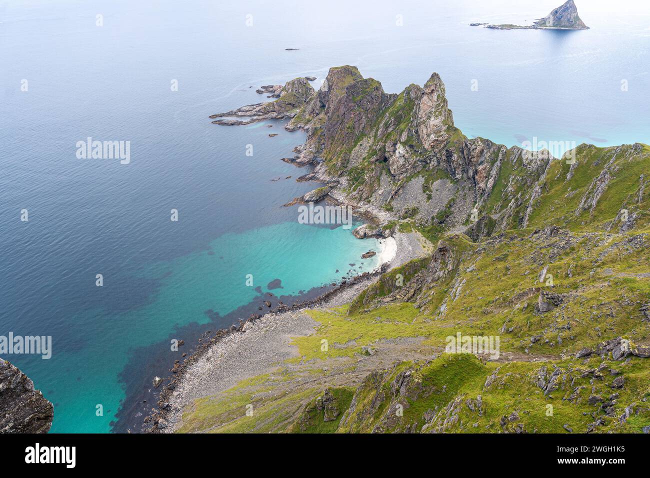 Kleiner Berg am Meer mit üppigem grünem Gras darüber Stockfoto