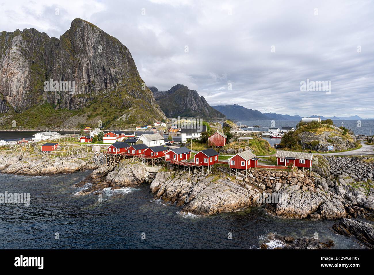 Rote Gebäude sitzen auf dem Wasser, eingerahmt von einem majestätischen Berg Stockfoto