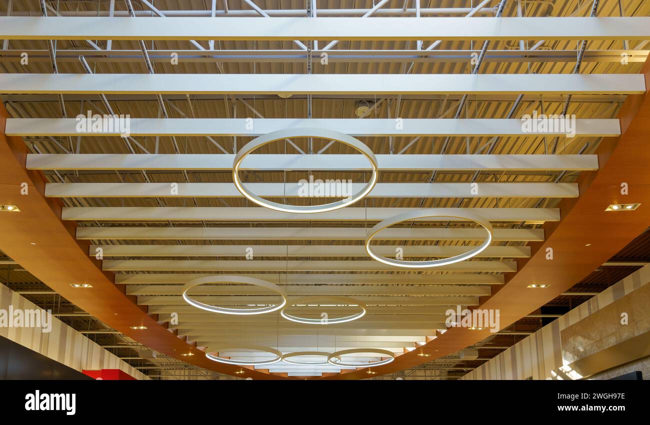 Kreisförmige elektrische Lampen in der Decke des Einkaufszentrums Vaughan Mills. Moderner Architekturstil im Innenraum des Geschäftsgebäudes Stockfoto