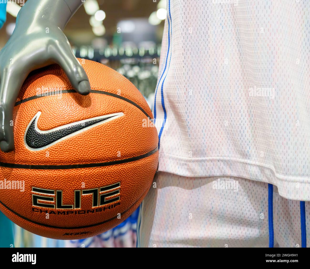 Eine Schaufensterpuppe hält einen Nike Sportball in einem Einzelhandelsgeschäft. Das Firmenlogo oder Swoosh ist Teil der Szene Stockfoto