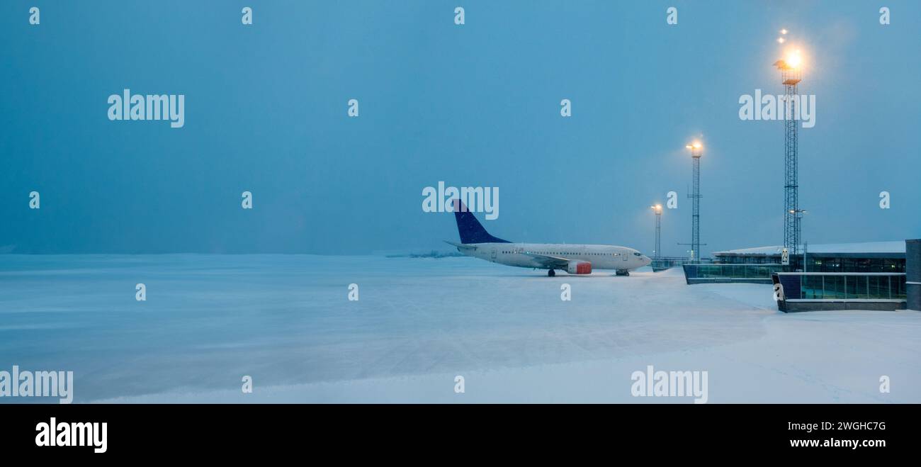 Leerer schneebedeckter Flughafen mit nur einem Flugzeug auf der Start- und Landebahn Stockfoto