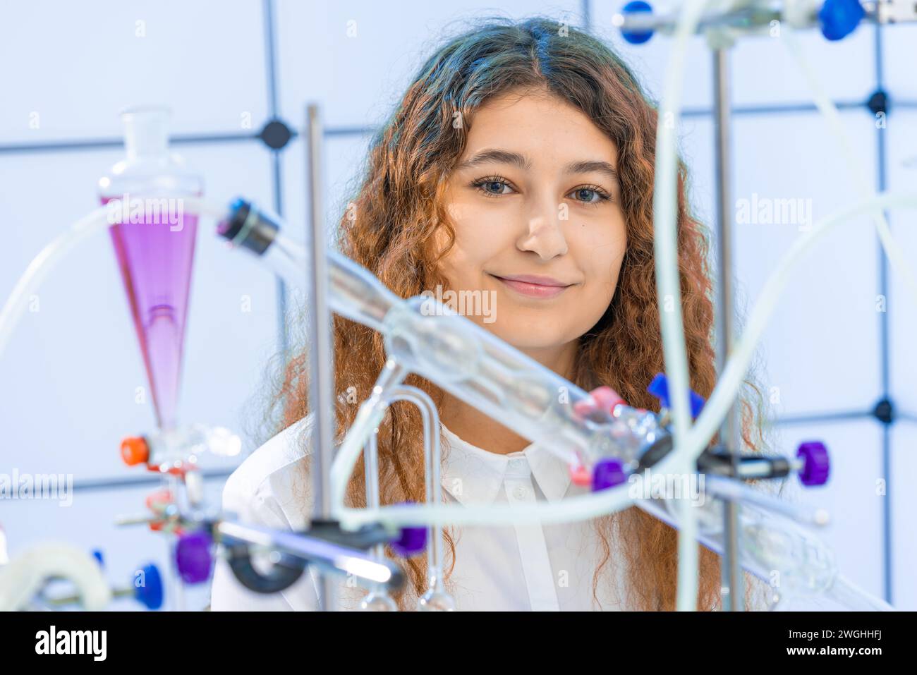 Junge Frau im Syntheselabor der organischen Chemie, Joyful Grin, der die Kamera ansieht Stockfoto