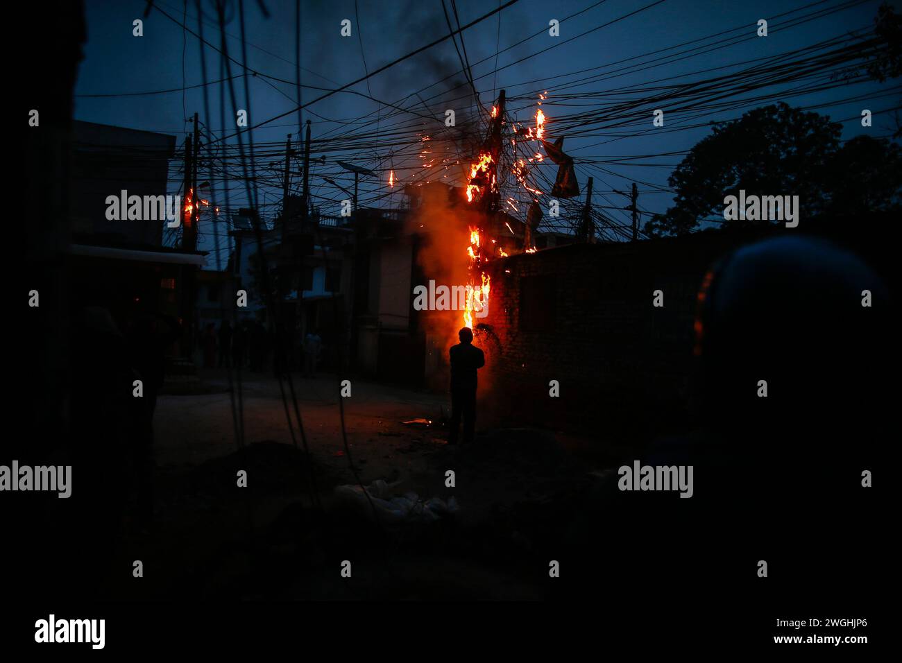 Kathmandu, Nepal. Februar 2024. Ein örtlicher Ort versucht, ein Feuer mit Sand zu begießen, der sich auf nicht verwalteten Stromkabeln befindet, was durch Kurzschlüsse in den frühen Morgenstunden verursacht wird. (Foto: Skanda Gautam/SOPA Images/SIPA USA) Credit: SIPA USA/Alamy Live News Stockfoto