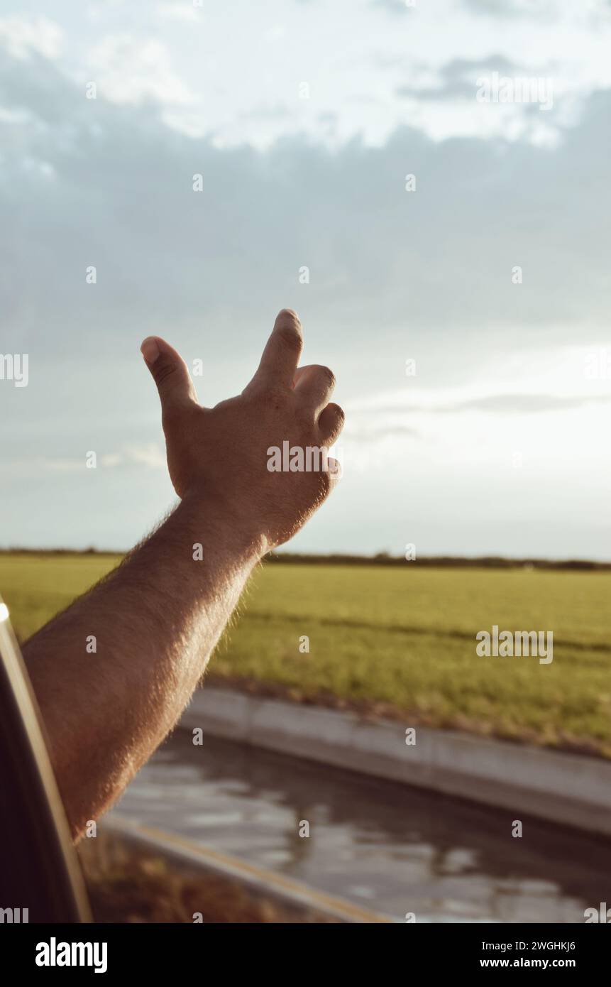 Die Hand eines Mannes, der am 29. August 2023 in Katalonien, Spanien, aus dem Fenster genommen wurde und die Luft spürt Stockfoto