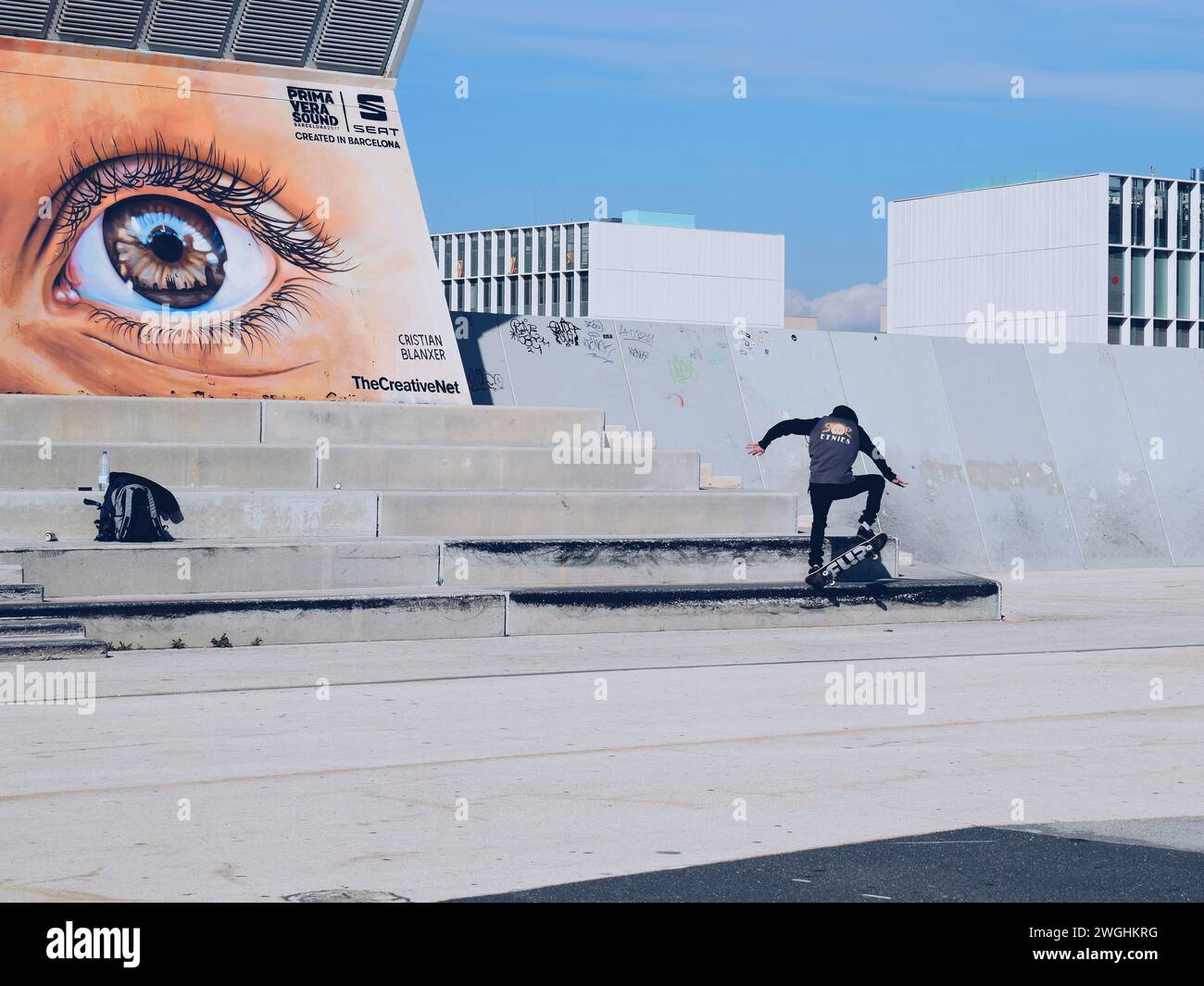 Skater üben mit einem Wandbild eines Auges im Hintergrund im Parc del Forum in Barcelona in Katalonien, Spanien, am 1. April 2019 Stockfoto