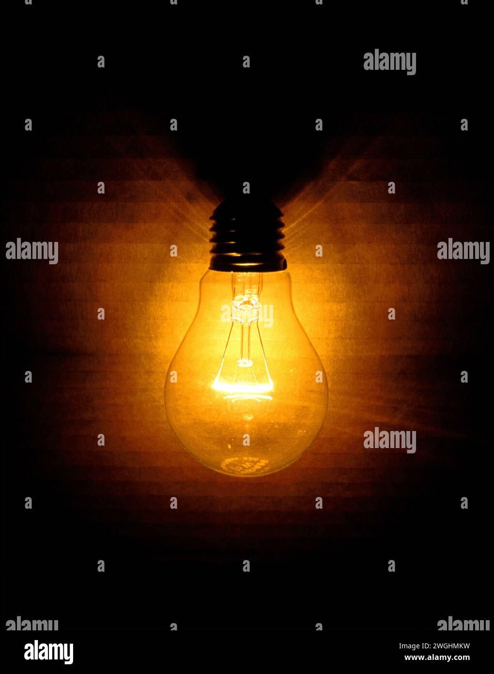 Warmes Licht einer leuchtenden gewöhnlichen Glühlampe mit Wolfram-Glühfaden Stockfoto