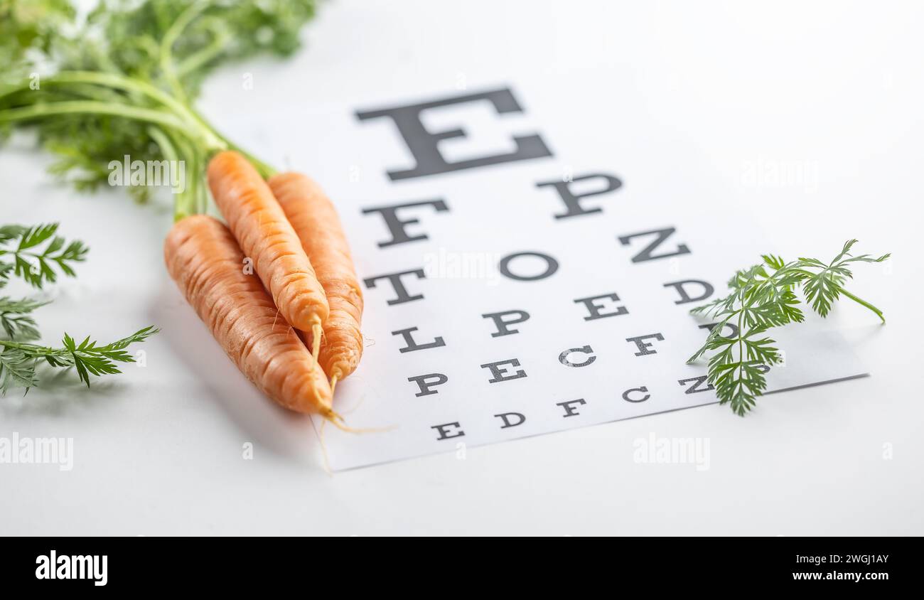 Frische Karotten als Vitamin-A-Quelle auf der Augentestkarte. Stockfoto