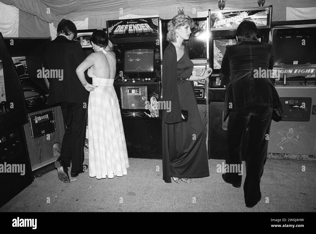 Wohlhabende junge Erwachsene aus der Mittelschicht spielen auf dem jährlichen Berkeley Square Ball London mit Space Invaders-Maschinen. Westminster, London, England September 1981. HOMER SYKES AUS DEN 1980ER JAHREN Stockfoto