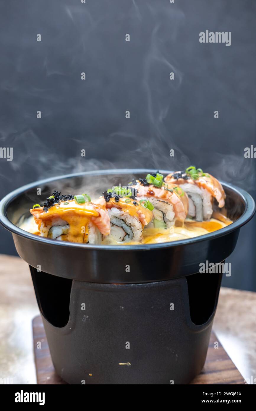Set mit Salmon Sushi-Rolle auf heißer Pfanne Stockfoto