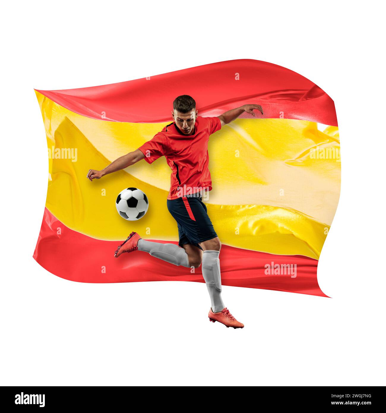 Konzentrierter Mann, Fußballspieler in Uniform, der Ball vor weißem Hintergrund mit der Flagge Spaniens schlägt Stockfoto