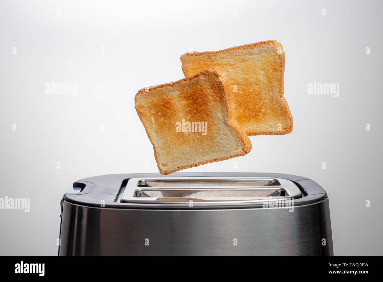 Moderne Toaster mit Brotscheiben auf weißem Hintergrund Stockfoto