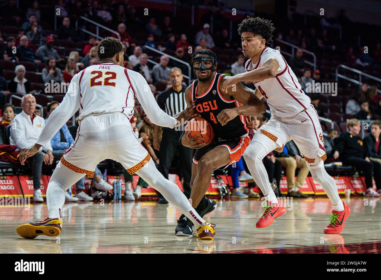 Der Oregon State Beavers Guard Dexter Akanno (4) spaltet die Verteidiger USC Trojans, die Oziyah Sellers (4) und Forward Arrinten Page (22) während eines NCAA-Männerteams Stockfoto