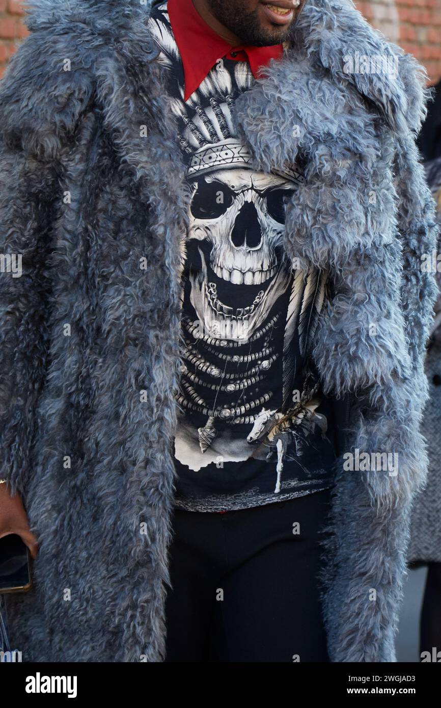 MAILAND, ITALIEN - 13. JANUAR 2024: Mann mit grauem Pelzmantel und Hemd mit Skull vor der Fendi Fashion Show, Mailand Fashion Week Street Style Stockfoto