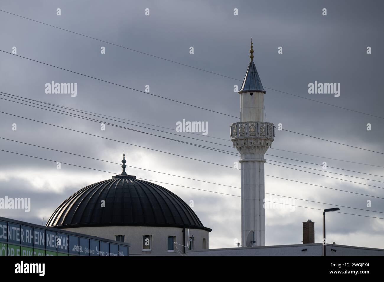 , Deutschland, Baden-Württemberg, Hockenheim, 05.02.2024, Moscheekuppel und Minarett unter düsteren Wolken. Stockfoto